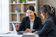 © amnaj - Two young Asian businesswomen discuss with new startup project Idea presentation, analyze planning and financial statistics and investment market on laptop computer at office.