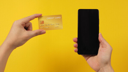 Smartphone with blank screen and black credit card in man hands.