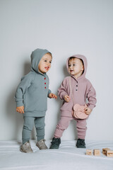 Baby fashion. Unisex gender neutral clothes for babies. Two Cute baby girls or boys in cotton set