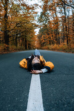 Confidence Woman Lying On The Road With Autumn Tree Around. New Life, Path Choice, Ambition, Direction