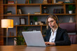 © Ivan - Attractive freelancer female talking in a video conference on line with a headset with microphone and laptop in an office desktop or home desk
