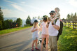 © MNStudio - Family of three having fun on a walk on Gubalowka mountain range. High Tatra mountains and green hills in summer or spring.