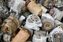 A pile of used car starters and generators, scrap electric motors