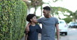 © Marco - Two brothers walking together in sidewalk. Black brother giving advice to younger sibling