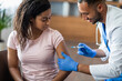Black lady getting vaccinated against coronavirus at clinic
