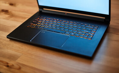 Laptop keyboard with orange neon illumination, backlit keyboard.