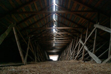 Abandoned Ruined Barn Cowshed Inside View. The Old Abandoned Barn With The Remains Of Feeders. Barn From Inside With Low Light