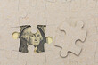 © Iurii Gagarin - Missing puzzle piece and framed US dollars. Background with copy space