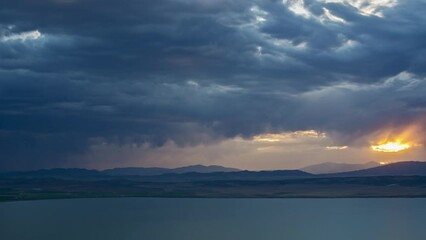 Wall Mural - Timelapse of sunset and rainstorm moving in towards Utah Lake as dark clouds roll through the sky.
