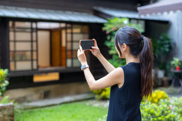 Wall Mural - Woman use mobile photo to take photo in Japanese house