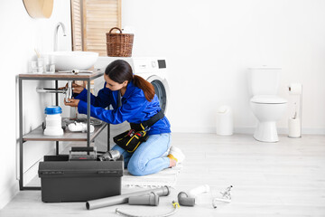 Poster - Female plumber fixing sink in bathroom