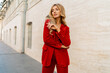 © Svetlana Sokolova - Profeshional fashion model in  elegant red velvet suit posin outdoor in old european city.    Blond wavy hairs, perfet skin, full lips.