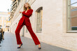 © Svetlana Sokolova - Outdoor fashion photo of elegant  blond woman posing on the street. Wearig casual red velvet dress.