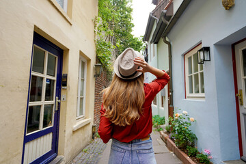 Wall Mural - Beautiful traveler woman walking in Schnoor neighborhood, Bremen, Germany