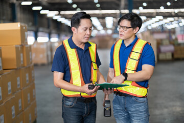 2 man manager and staff  working in the large storage warehouse meet agreement concluded on how goods and boxes, wooden pallet stacked in the warehouse for proper arrangement and easy to find
