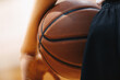 Basketball player holding game ball. Basketball training session. Closeup image of basketball