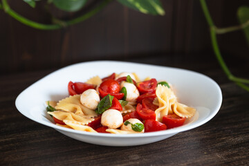 Wall Mural - Pasta salad with tomato, mozzarella and basil. Quick and cold summer dish, ideal for a vegetarian diet. Convenient food to take to the office.