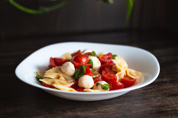 Wall Mural - Pasta salad with tomato, mozzarella and basil. Quick and cold summer dish, ideal for a vegetarian diet. Convenient food to take to the office.