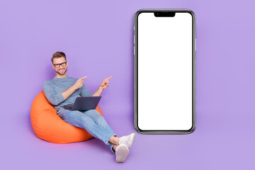 Poster - Photo of busy cute guy dressed grey shirt sitting bean bag writing gadget empty space isolated purple color background