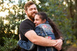 © Austockphoto - Happy young people hug with man looking at the camera