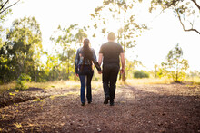 Couple Walk Up Hill Hand In Hand Along Track