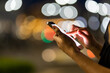 © F8  \ Suport Ukraine - Woman hands using her mobile phone, city skyline night light background