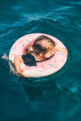 Wall Mural - Baby girl swimming with Inflatable ring in the sea.