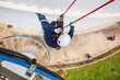 © chitsanupong - Focus top view male worker down height tank roof rope access safety inspection of thickness storage tank gas