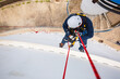 © chitsanupong - Focus top view male worker down height tank roof rope access safety inspection of thickness storage tank gas