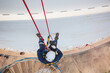 © chitsanupong - Focus top view male worker down height tank roof rope access safety inspection of thickness storage tank gas