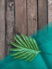 Wall Mural - leaves and table clothing on wood background 