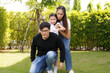 © atitaph - Asian family happy bright cute daughter is resting by playing in the grass let daughter ride father's neck