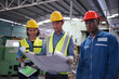 © FotoArtist - Three Heavy Industry Engineers Stand in Pipe Manufacturing Factory, Use Digital Tablet Computer, Have Discussion. Design and Construction