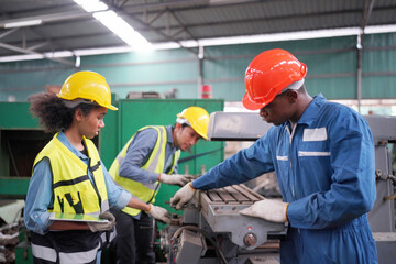 Team maintenance engineers men and women inspect relay protection system with laptop comp. They work a heavy industry manufacturing factory.