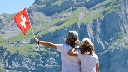 Wall Mural - young boys holding Swiss flag in Mountain View- travel, tourism, vacation family concept