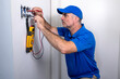 © spatesphoto - Electrician Testing a Toggle Switch Inside a Home