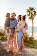© Erin Brant/Stocksy - Young girls and laughing parents near ocean
