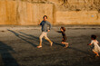 © Erin Brant/Stocksy - Happy daughters chasing dad on beach
