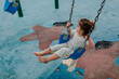 © Erin Brant/Stocksy - Barefoot young girl on swing