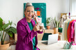 © Eloisa Ramos/Stocksy - Senior woman calling by phone having coffee at office