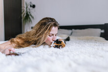 Attractive Woman Showing Love To Cute Multicolored Cat In Apartment