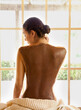 © Trinette Reed/Stocksy - Woman relaxing at spa with skincare mud treatment on her back