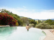 © Trinette Reed/Stocksy - Man soaking in hot tub pool on vacation at luxury resort and spa