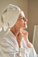 Middle Aged Woman Cleansing Neck With Cotton Pads