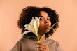 © Valentina Barreto/Stocksy - African woman with flowers studio shot
