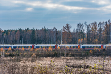 Wall Mural - Passenger train moves at autumn morning time.