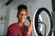 © Ezequiel Giménez/Stocksy - Black blogger applying makeup and recording video