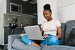 © Ezequiel Giménez/Stocksy - Positive teenager using laptop in living room