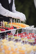 Catering on wedding. Waiters serving table in the restaurant preparing to receive guests. Wedding banquet table. Sweet table with fruit. Fruit bar on party. Delicious fruits appetizers.