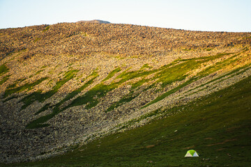 Wall Mural - Green tent stand by mountains on sunset outdoors. Solitude in nature concept